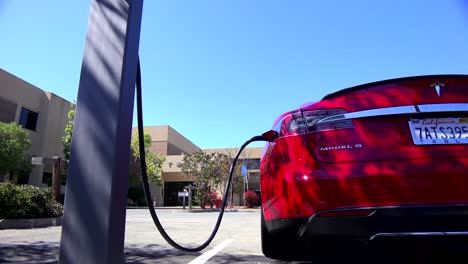 Traveling-shot-along-the-back-of-a-Tesla-electric-car-as-it-charges