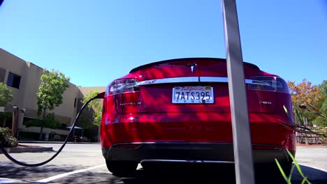 Reiseaufnahme-Entlang-Der-Rückseite-Eines-Tesla-Elektroautos,-Während-Es-1-.-Aufgeladen-Wird