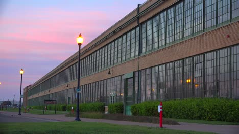 An-establishing-shot-of-a-warehouse-or-factory-at-sunset