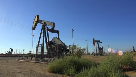 Establishing-shot-of-an-oil-field-with-derricks-pumping