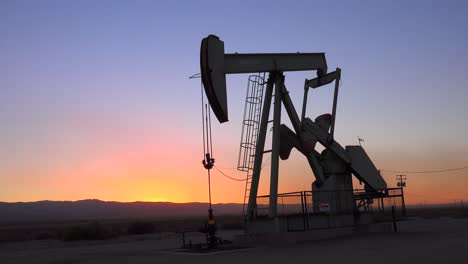 An-oil-derrick-pumps-against-the-horizon-at-dusk