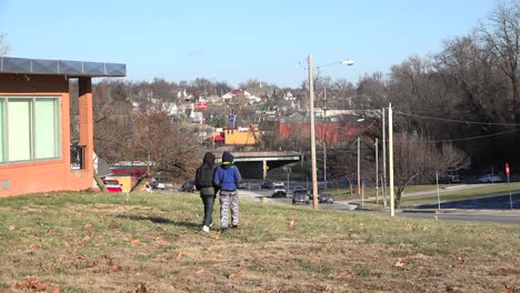 Two-young-African-American-boys-walk-on-a-hill-above-the-town-of-Ferguson-Missouri