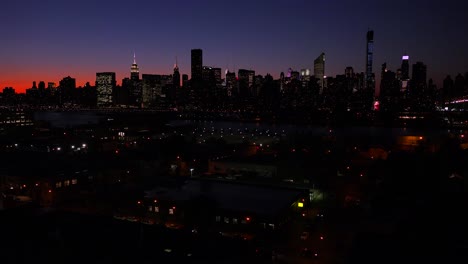 A-wide-angle-view-over-Queens-New-York-City-at-dusk-with-the-Manhattan-skyline-background