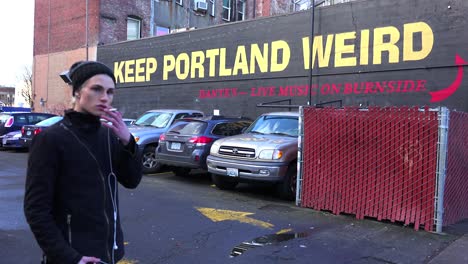 Ein-Mann-Steht-Vor-Einem-Schild-An-Einem-Gebäude,-Das-Besucher-Auffordert,-Portland-Seltsam-Zu-Halten
