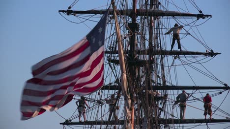 Sailors-stand-on-the-mast-of-a-tall-historic-clipper-ship-as-it-sails-on-the-ocean