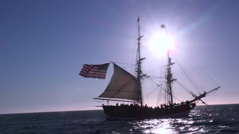A-tall-masted-clipper-ship-sails-on-the-high-seas-with-an-american-flag-flying