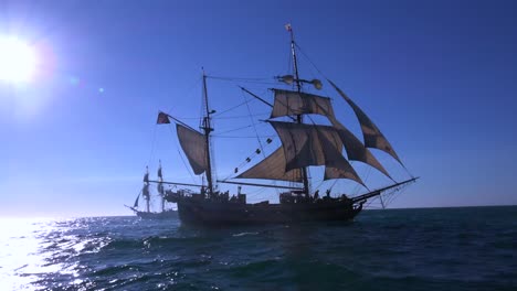 A-tall-masted-clipper-ship-sails-on-the-high-seas-against-the-sun