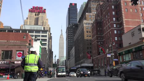 Ein-New-Yorker-Polizist-Regelt-Den-Verkehr-Mit-Dem-Empire-State-Building-Im-Hintergrund-1