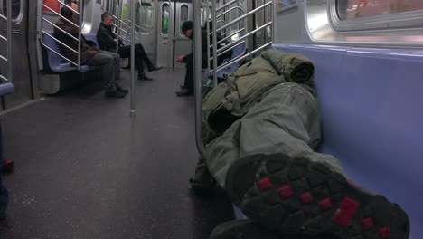 A-homeless-man-sleeps-in-a-subway-train