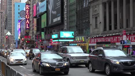 Traffic-passes-along-Broadway-with-signs-advertising-the-latest-shows