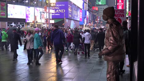 Crowds-of-people-walk-past-a-mime-in-New-York's-Times-Square