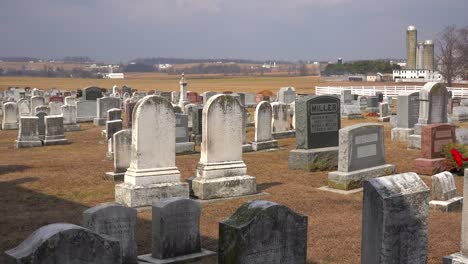 An-establishing-shot-of-an-Amish-graveyard-in-Pennsylvania-with-a-farm-distant-1