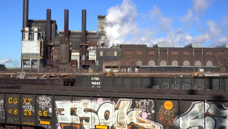 Global-warming-is-suggested-by-shots-of-a-steel-mill-belching-smoke-into-the-air-with-railcars-foreground-3