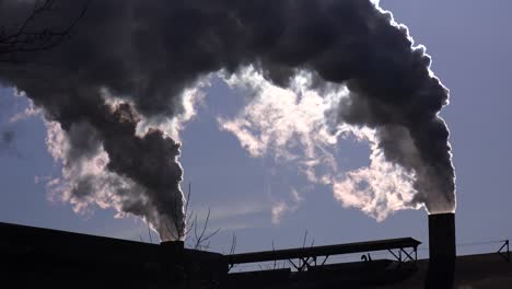 Global-warming-is-suggested-by-shots-of-a-steel-mill-belching-smoke-into-the-air-with-sun-background-2