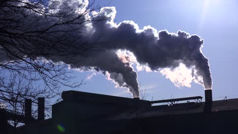 Global-warming-is-suggested-by-shots-of-a-steel-mill-belching-smoke-into-the-air-with-sun-background-3