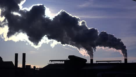 Global-warming-is-suggested-by-shots-of-a-steel-mill-belching-smoke-into-the-air-with-sun-background-5