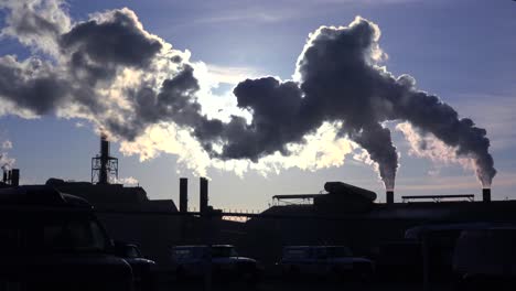 Global-warming-is-suggested-by-shots-of-a-steel-mill-belching-smoke-into-the-air-with-sun-background-6