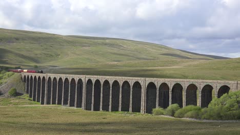 A-steam-train-passes-over-a-long-stone-viaduct-bridge-in-the-English-countryside-1