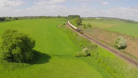 An-aerial-of-a-diesel-passenger-train-as-it-passes-through-the-English-countryside-at-high-speed