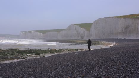 A-woman-walks-along-the-White-Cliffs-of-Dover-near-Beachy-Head-in-Southern-England