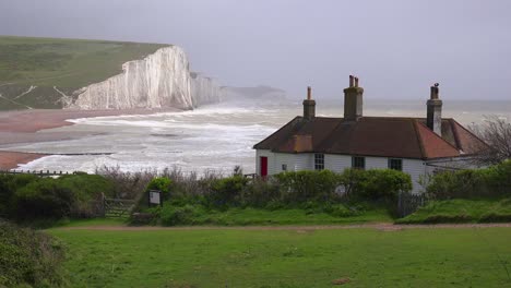 Establishing-shot-of-the-beautiful-houses-along-the-shore-of-the-White-Cliffs-of-Dover-at-Beachy-Head-England