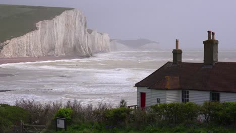 Establishing-shot-of-the-beautiful-houses-along-the-shore-of-the-White-Cliffs-of-Dover-at-Beachy-Head-England-1