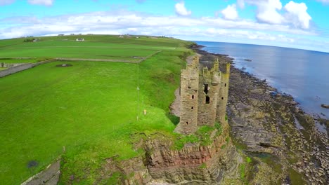 A-beautiful-aerial-shot-over-an-abandoned-castle-along-the-North-Coast-of-Scotland-