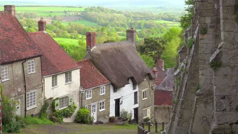 Idyllic-hillside-cottages-line-a-steep-cobblestone-road-in-the-English-countryside