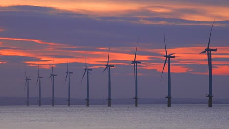 A-wind-farm-generates-electricity-along-a-coastline-at-sunset-4