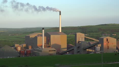 An-industrial-plant-belching-smoke-in-green-rolling-hills-of-England