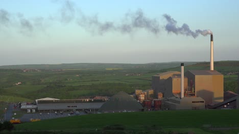 An-industrial-plant-belching-smoke-in-the-green-rolling-hills-of-England