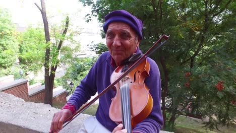 A-colorful-old-gypsy-man-plays-the-violin-in-a-park-in-Budapest-Hungary