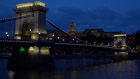 Night-view-beside-an-illuminated-bridge-over-the-Danube-River-in-Budapest-Hungary-1