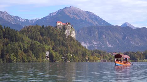 Ein-Ruderboot-Passiert-Das-Fort-Auf-See-Bled-Slowenien