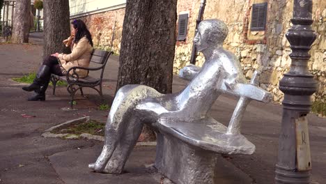 An-artistic-rendition-of-a-person-sitting-on-a-bench-sits-near-a-real-person-sitting-on-a-park-bench