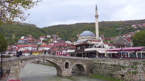 Establishing-shot-of-a-town-in-Kosovo-with-bridge-and-mosque