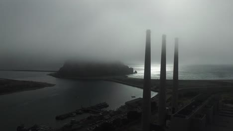 Aerial-over-large-power-plant-smokestacks-in-the-fog-near-Morro-Bay-California