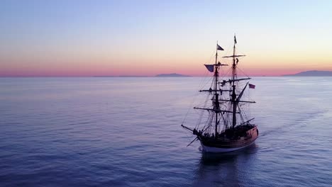 Spectacular-aerial-of-a-tall-sailing-ships-on-the-open-ocean-at-sunset