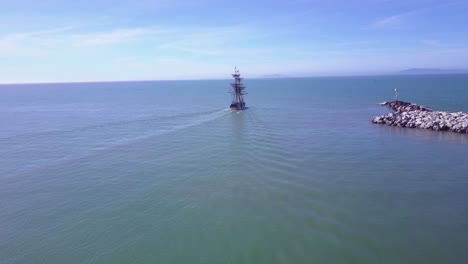 An-aerial-follows-a-tall-ship-leaving-Ventura-harbor-California