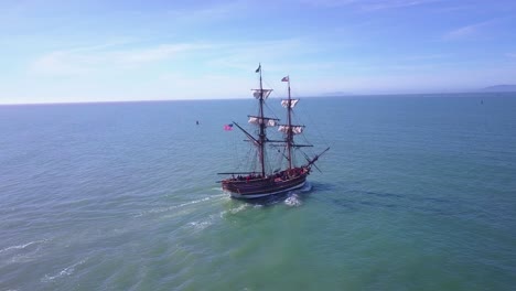 Spectacular-aerial-following-a-tall-sailing-ship-on-the-open-ocean-by-day
