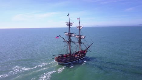 Spectacular-aerial-following-a-tall-sailing-ship-on-the-open-ocean-by-day-1