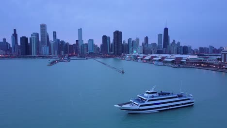Eine-Schöne-Antenne-Um-Einen-Großen-Yachtmarinepier-In-Chicago-Mit-Der-Skyline-Hintergrundnacht-Der-Stadt