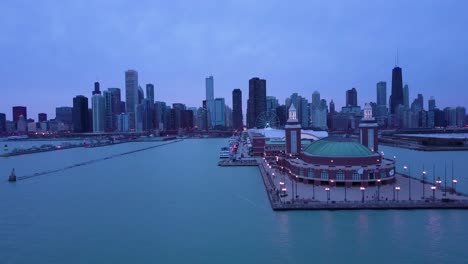 Eine-Schöne-Antenne-Um-Den-Navy-Pier-In-Chicago-Mit-Der-Skyline-Der-Stadt-Im-Hintergrund-Nacht-1