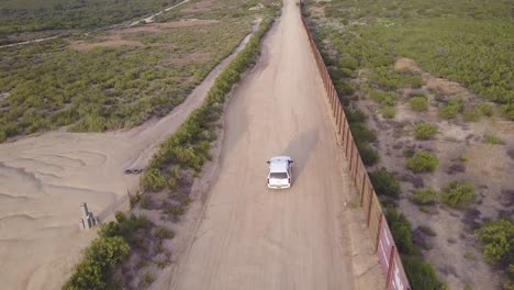 Aerial-over-a-border-patrol-vehicle-standing-guard-near-the-border-wall-at-the-US-Mexico-border-4