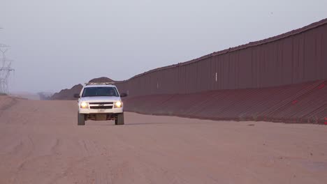 Border-patrol-vehicle-moves-slowly-near-the-border-wall-at-the-US-Mexico-border-at-Imperial-sand-dunes-California-1