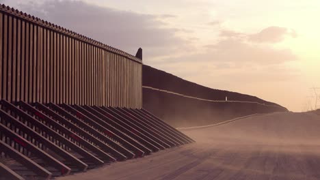Dust-blows-at-sunset-at-the-border-wall-at-the-US-Mexico-border-near-Imperial-sand-dunes-California