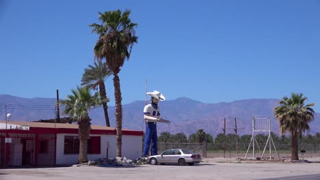 A-large-statue-of-a-cowboy-stands-outside-a-desert-bar-or-saloon-1