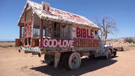 A-truck-painted-with-Bible-verses-and-promoting-Jesus-sits-at-a-Christian-hippy-commune-at-Slab-City-California