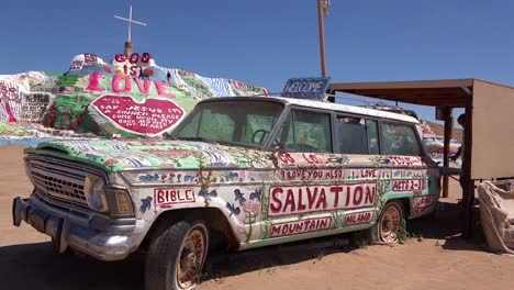 A-car-painted-with-Bible-verses-and-promoting-Jesus-sits-at-a-Christian-hippy-commune-at-Slab-City-California