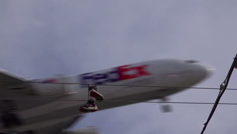 A-nice-low-angle-of-tennis-shoes-on-a-line-as-a-FedEx-plane-lands-in-Southern-California